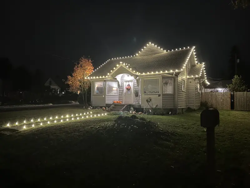 A cottage-style home warmly lit for Christmas