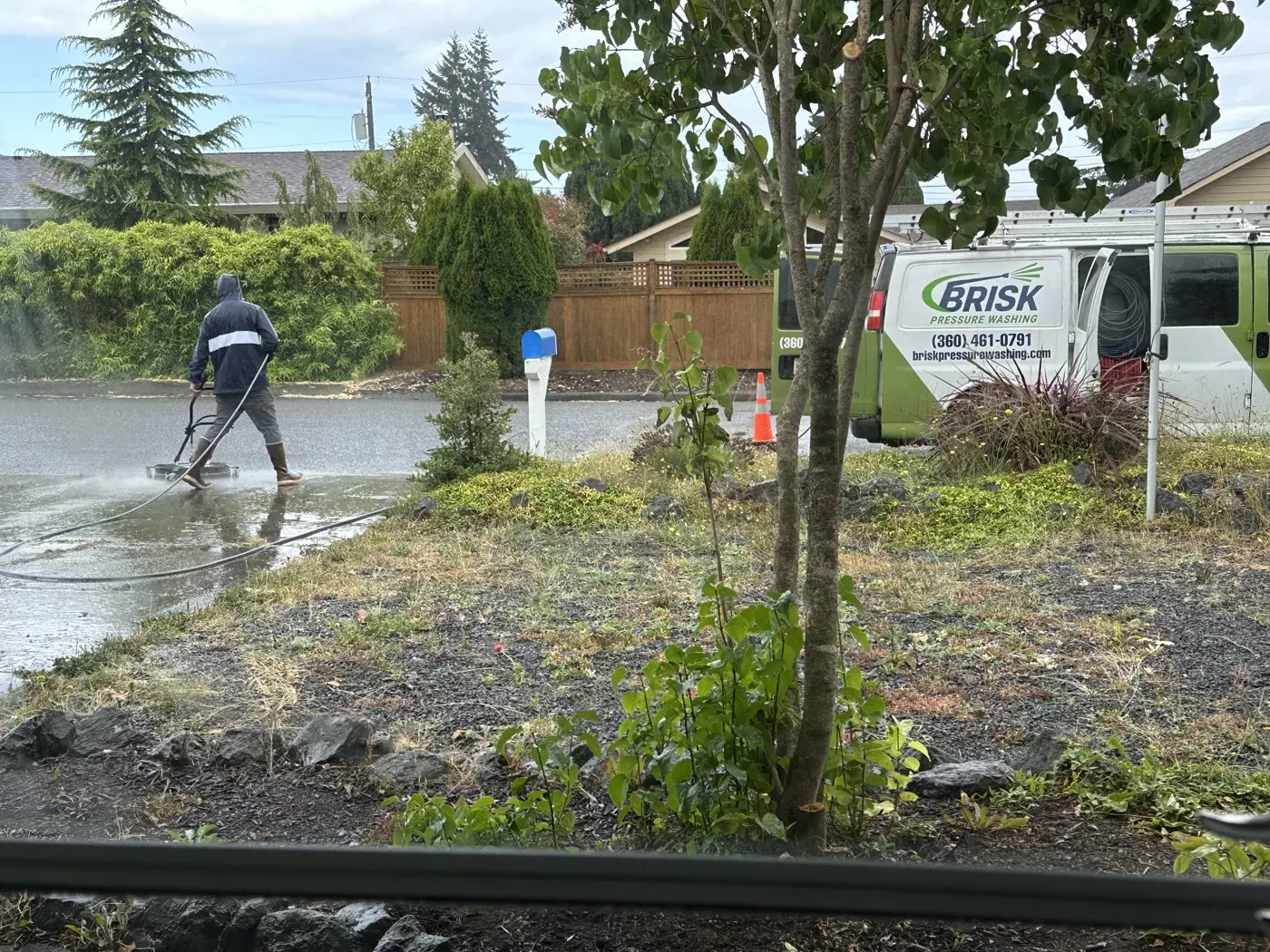 Tim from Brisk Pressure Washing working, van parked on site